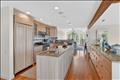 Gourmet kitchen with exposed wood beams, flowing to the breakfast nook