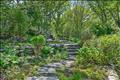 A beautifully landscaped, private woodland approach to the front door