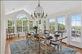 The dramatic arched windows and a classic statement chandelier, this bright and airy room offers panoramic views of the surrounding landscape and opens directly onto the expansive back deck, creating a flawless indoor-outdoor flow for entertaining