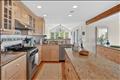 Open-concept kitchen featuring stainless steel appliances and custom cabinetry