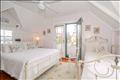 Primary bedroom features a high ceiling and an airy, light filled atmosphere.